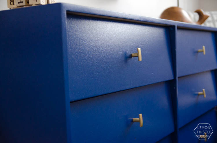 This bold blue dresser with brass hardware is perfect! And I love the floating frames above. Not too 'kiddish'