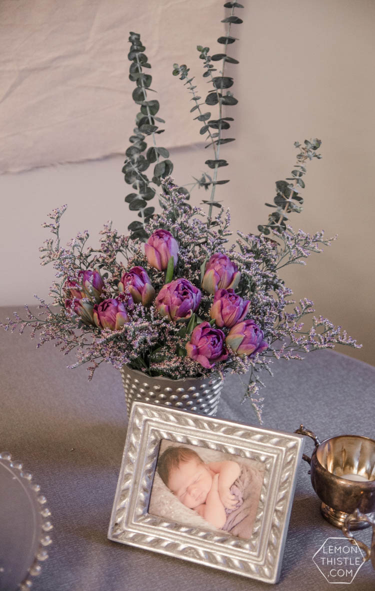 Simple baby shower decor for a girl- purple tulips with eucalyptus and baby photos