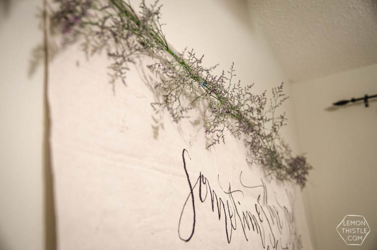 simple floral garland on top of a giant wall hanging for baby shower decor