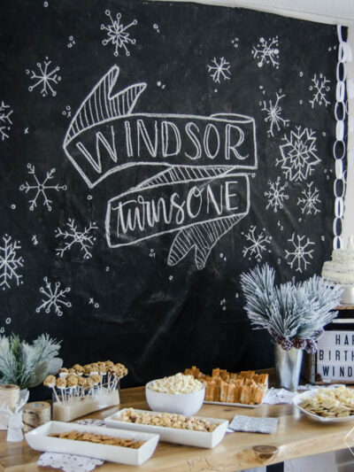 What a clever idea! Using a dropcloth to create a DIY giant chalkboard backdrop for birthday party decorations! Perfect for this modern winter wonderland!
