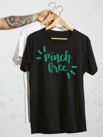 hand holding shirts on hangers, pinch free hand lettered design on shirt in green