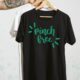 hand holding shirts on hangers, pinch free hand lettered design on shirt in green