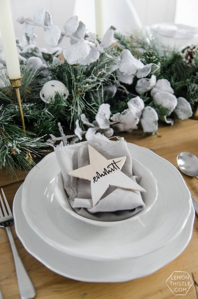 So pretty! A frosted holiday tablescape- DIY place cards and simple garland table runner... perfect for Christmas or any winter dinner party!