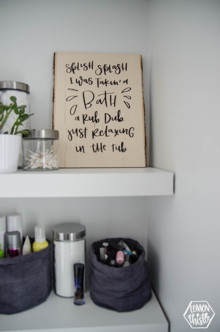 DIY Wood Sign for Bathroom. A wood Plank with black lettering (iron on vinyl) reads: Splish Splash I was takin' a bath. Rub dub just relaxing in the tub.
