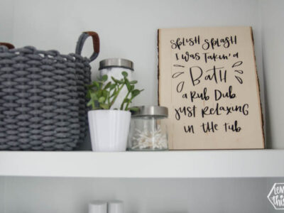 DIY Wood Sign for Bathroom. A wood Plank with black lettering (iron on vinyl) reads: Splish Splash I was takin' a bath. Rub dub just relaxing in the tub.