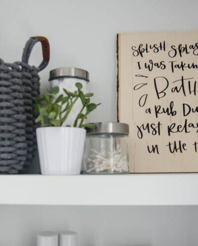 DIY Wood Sign for Bathroom. A wood Plank with black lettering (iron on vinyl) reads: Splish Splash I was takin' a bath. Rub dub just relaxing in the tub.