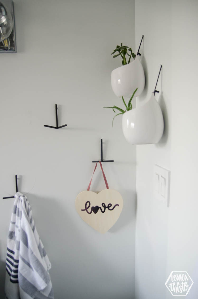 Photo of wooden heart sign with script word love in pink foil.