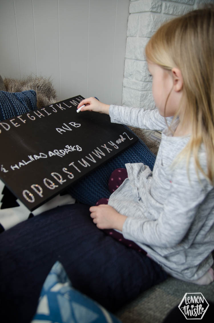 girl using chalkboard to practice letters- glitter vinyl alphabet applied with heat transfer vinyl