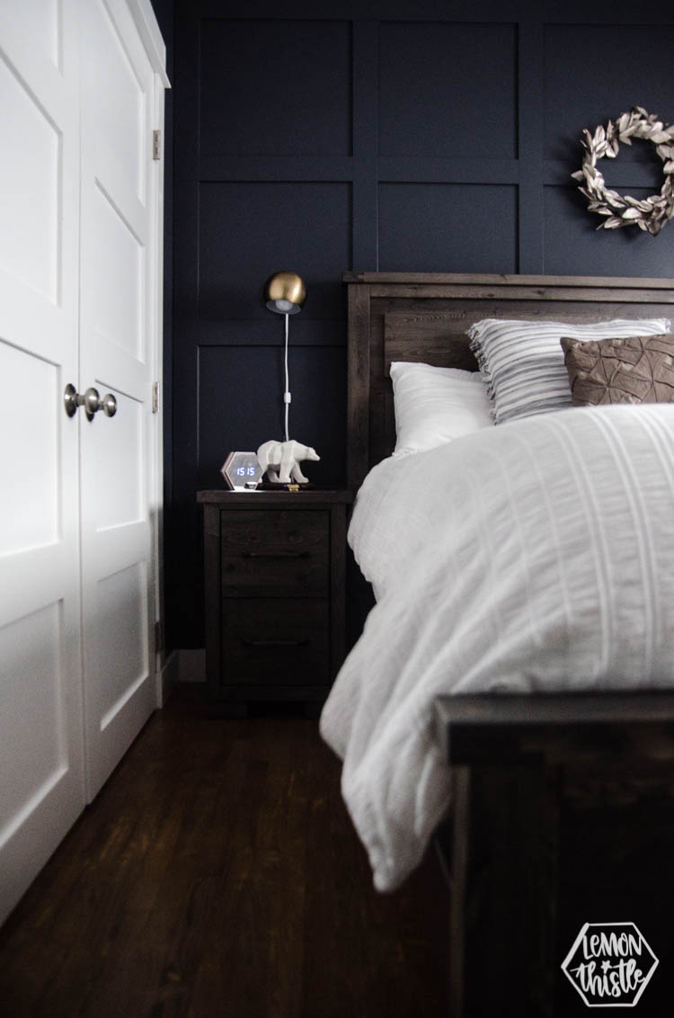 Navy Master Bedroom- King Bed with white bedding, wooden headboard and moulding wall