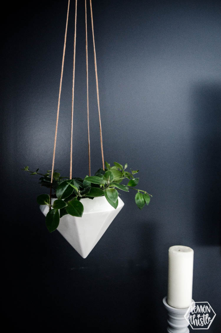 white geometric hanging planter with leather strings in navy bedroom