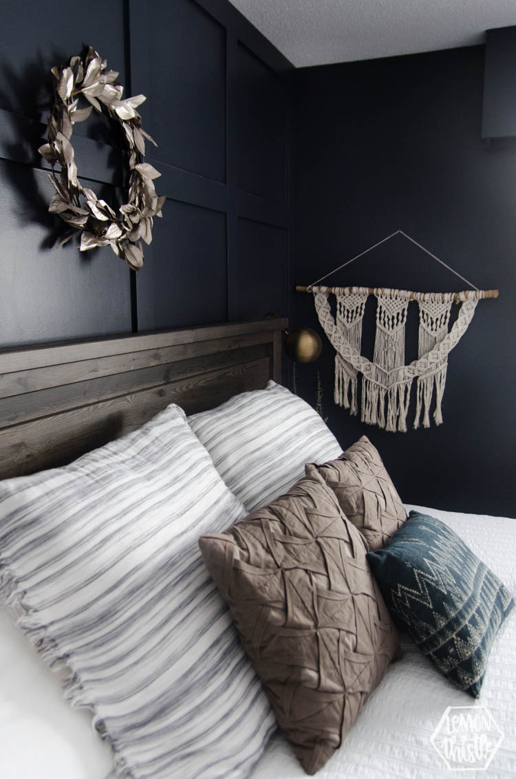 Macrame and metallic wreath decor in navy master bedroom