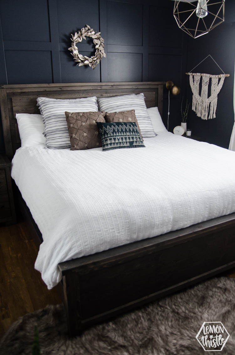 King bed with white quilted duvet cover and moulding feature wall