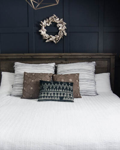 King bed with white quilted duvet cover and moulding feature wall