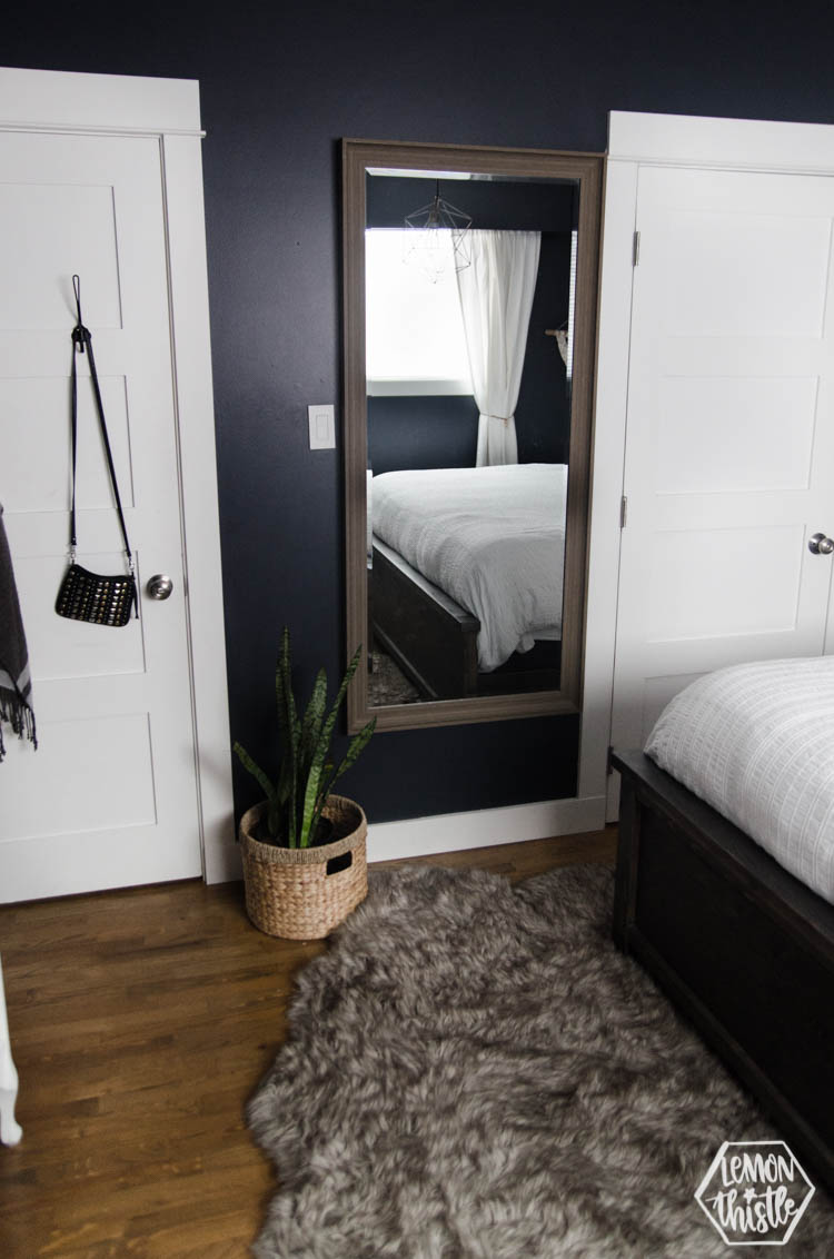 large mirror hung on navy wall in master bedroom- for tight spaces