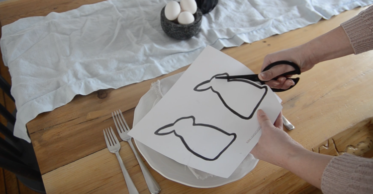 Use scissors to cut out Easter bunny silhouettes for modern place setting