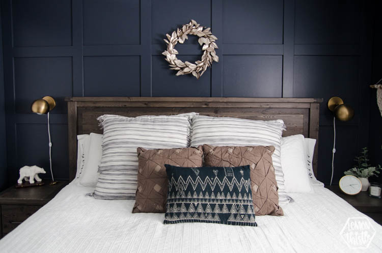 Made bed with his and hers pillowcases peeking out from behind all the throw pillows