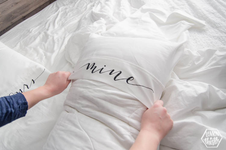 Putting on a king size pillow cover with the lettering 'mine'