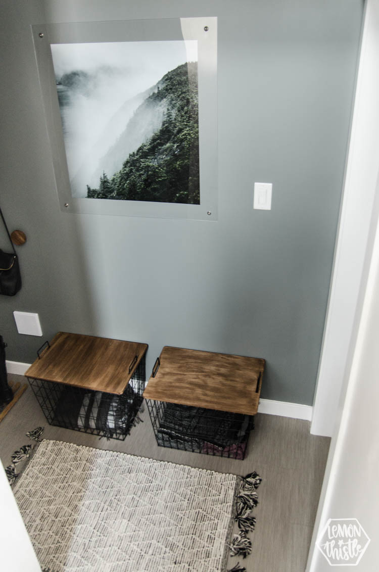 looking down at bottom of split level entry stairs to mini mudroom