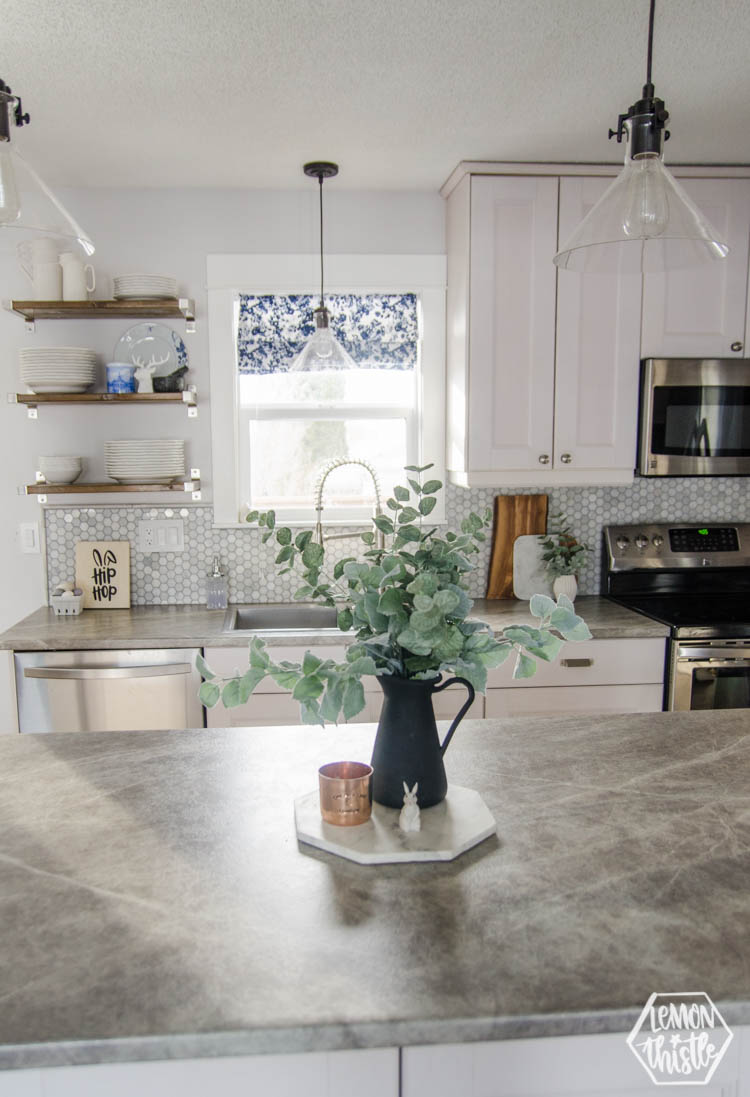 white and grey kitchen with open shelving decorated for spring