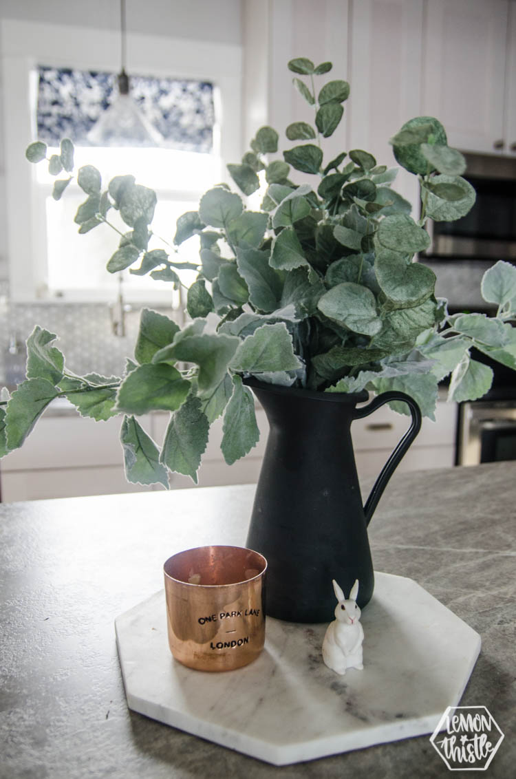 faux eucalyptus in black vase on kitchen island for spring decorating