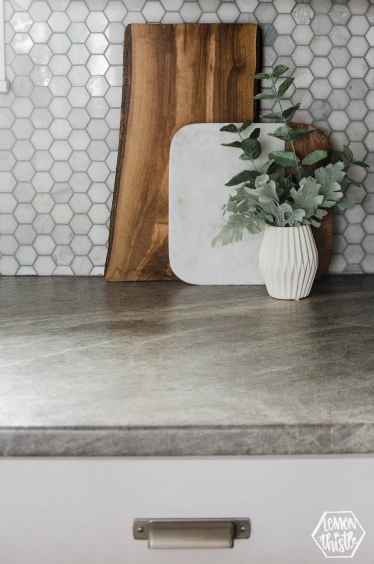serving boards on counter with vase of greens