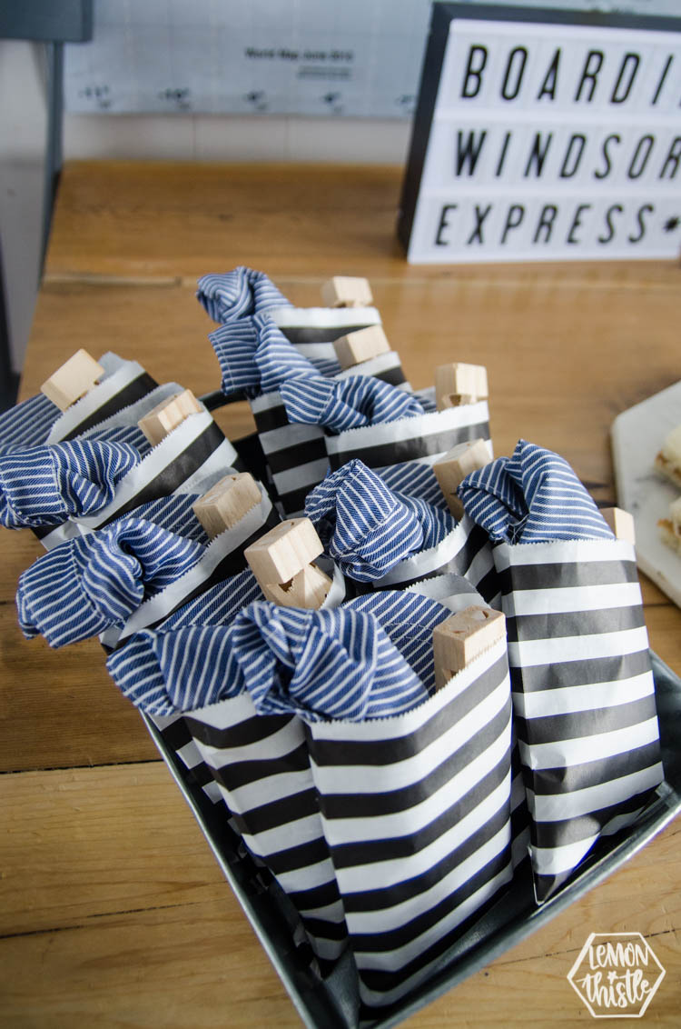 Cute party favours for a train themed party- conductor hats and train whistles in a striped bag