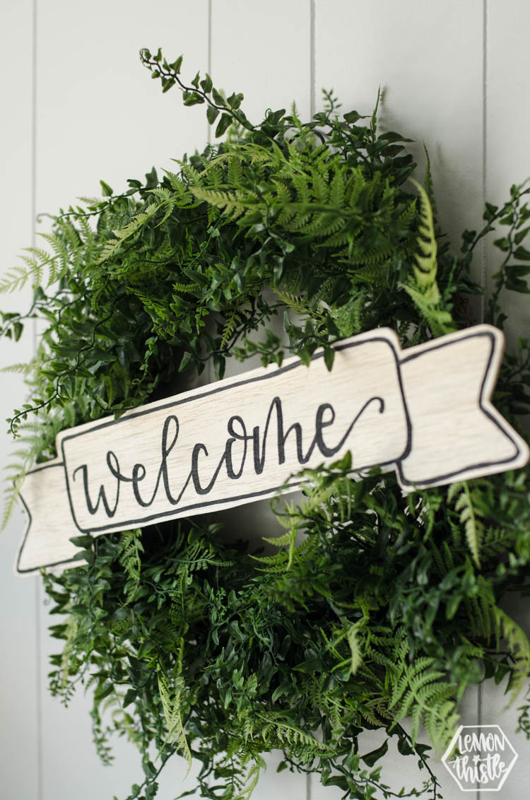 boxwood wreath with wooden welcome sign
