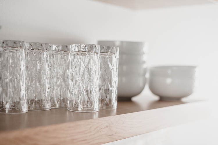 Pretty glasses and plain white dishes for practical but pretty open shelving in the kitchen