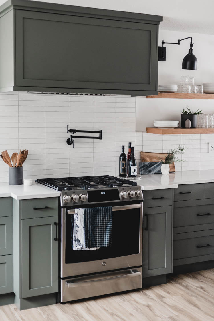 Modern black pot filler with green cabinets... so good!