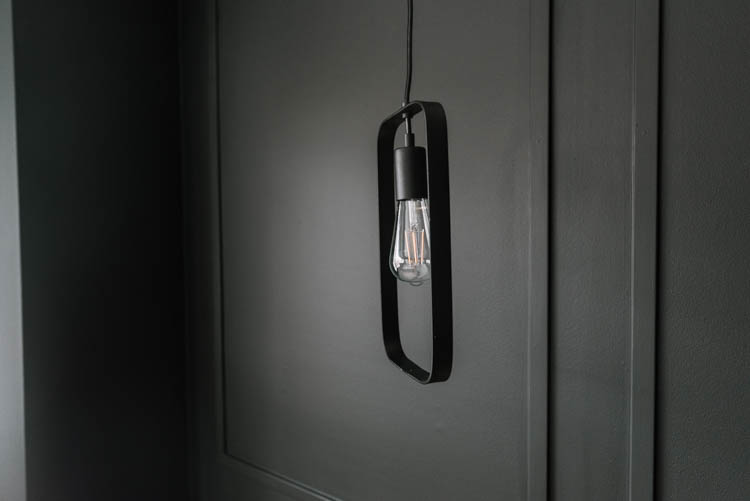 Moody black moulding wall with hanging black pendant lighting