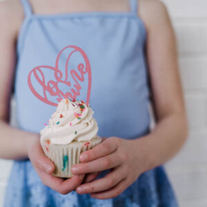 Girl holding cupcake with be mine cake topper