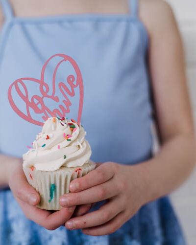 Girl holding cupcake with be mine cake topper