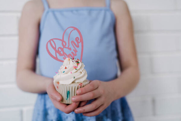 Girl holding cupcake with be mine cake topper