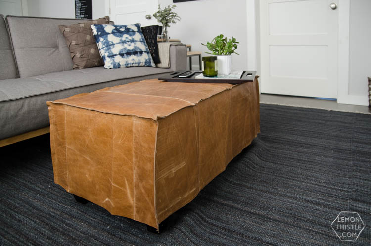 A DIY leather slip cover for a storage ottoman... so clever!