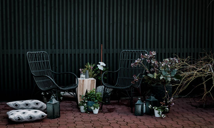 Modern brick patio- love the black wicker chairs!
