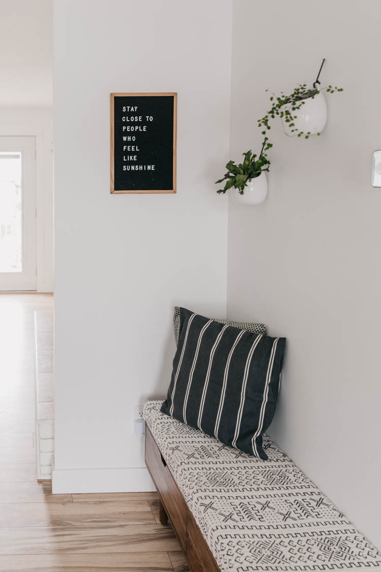 Entryway nook with plants and a letterboad... love the storage bench