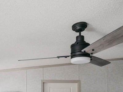 Beautiful farmhouse style fan on a sloped ceiling- great tips to install it on an angled ceiling