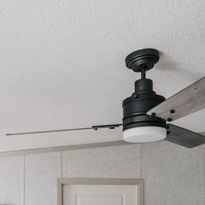 Beautiful farmhouse style fan on a sloped ceiling- great tips to install it on an angled ceiling