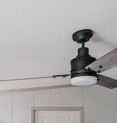 Beautiful farmhouse style fan on a sloped ceiling- great tips to install it on an angled ceiling