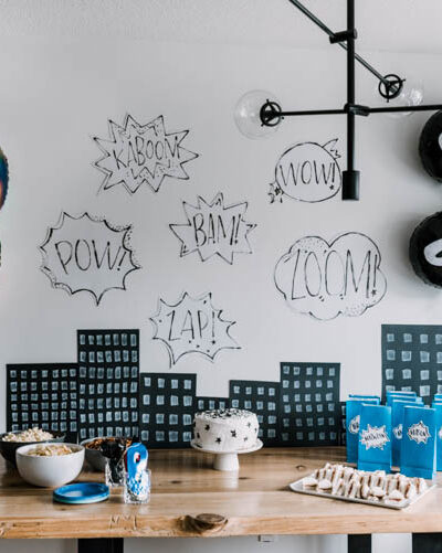 Tablescape with cartoon buildings and word bubbles for superhero birthday party