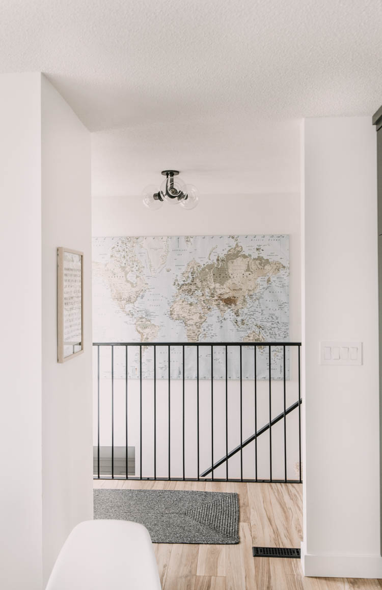 Modern Entryway Makeover- love the giant map over the stairs wall... those big walls are so hard to decorate!