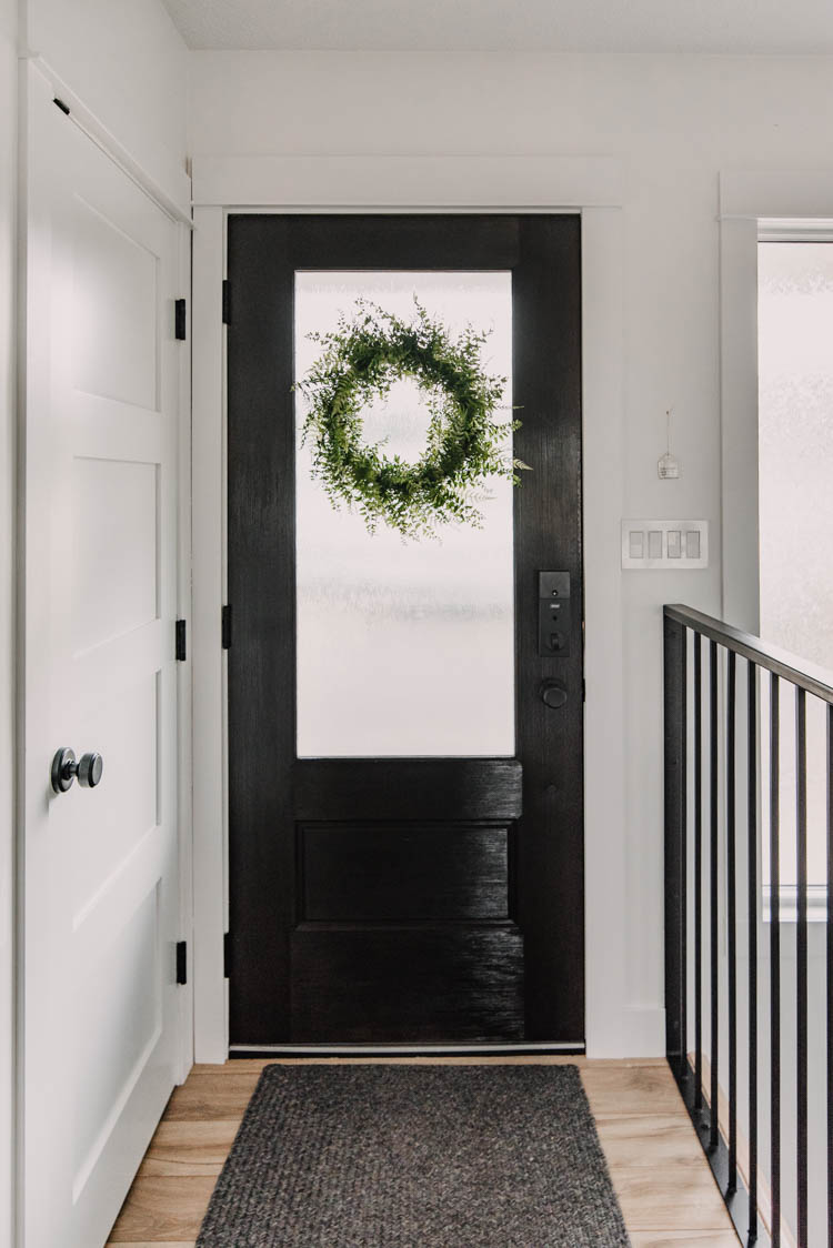 Black Door in the entry way with 3/4 glass