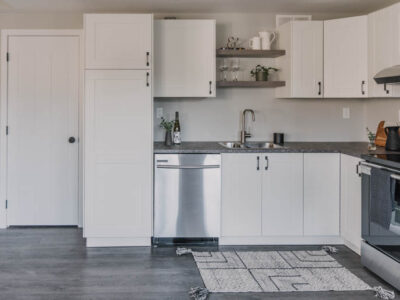 Modern basement kitchen with black hardware and white shaker cabinets