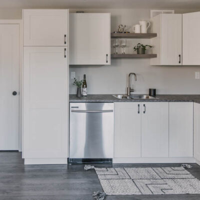 Modern basement kitchen with black hardware and white shaker cabinets