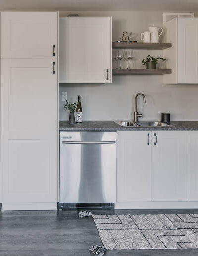 Modern basement kitchen with black hardware and white shaker cabinets
