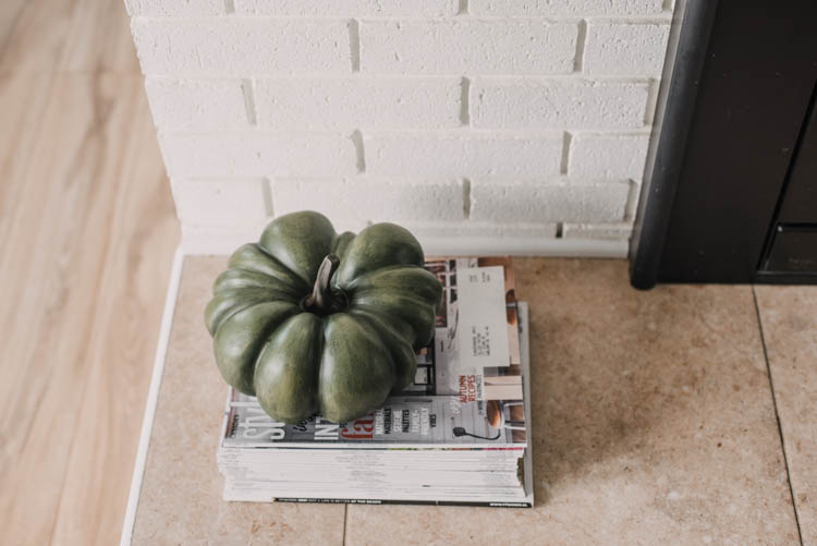 Heirloom faux pumpkin on stack of magazines