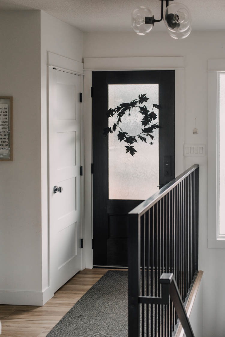 DIY Minimalist Halloween Wreath with black leaves and paper spiders