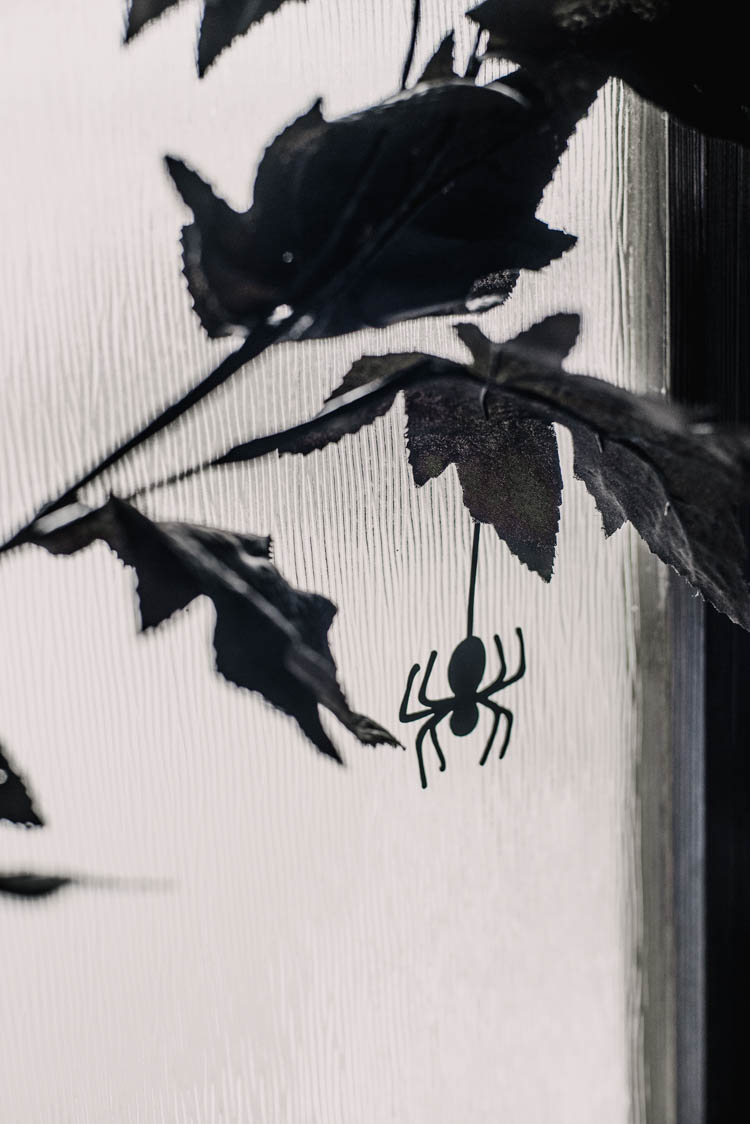 DIY Minimalist Halloween Wreath with black leaves and paper spiders