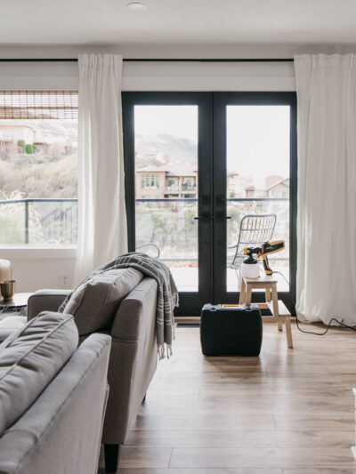 How we painted our patio doors black (including masking off the living room!) and the before and after- it makes SUCH a big difference in the feel of the space