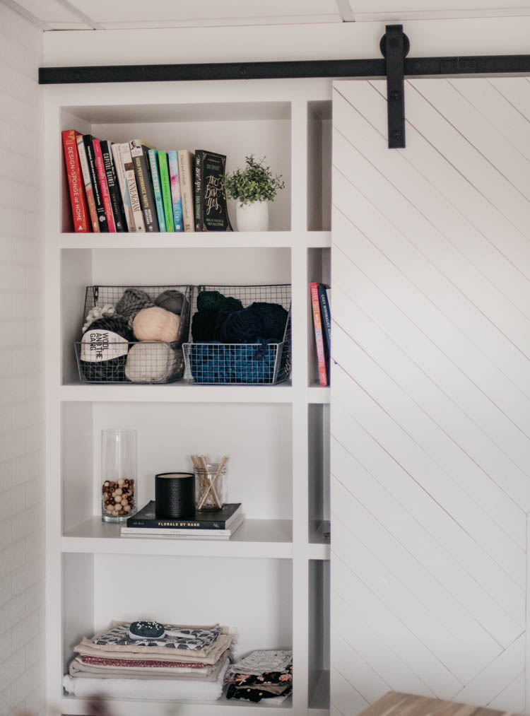 DIY built in shelving with barn door overtop for a studio 